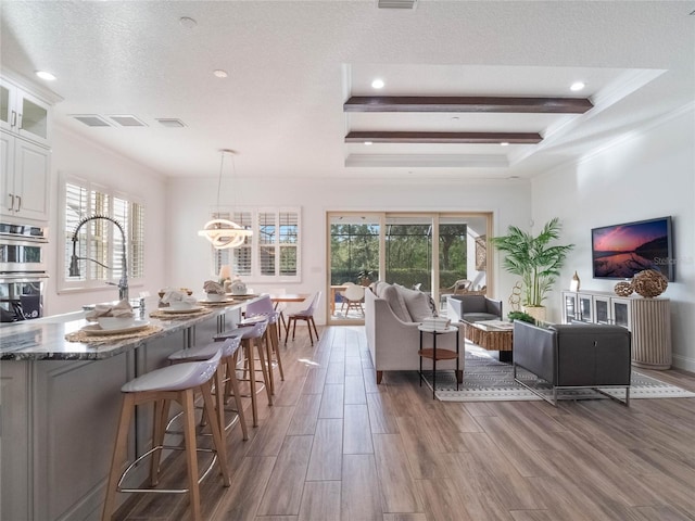 living room with beam ceiling, a healthy amount of sunlight, dark hardwood / wood-style floors, and a textured ceiling