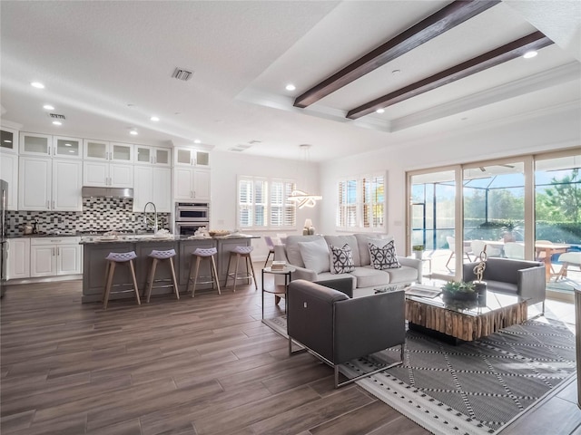 living room with ornamental molding, a healthy amount of sunlight, and dark hardwood / wood-style floors