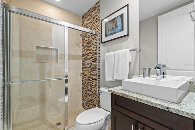 bathroom featuring an enclosed shower, vanity, and toilet