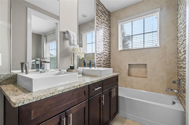 bathroom with vanity, a wealth of natural light, and a tub