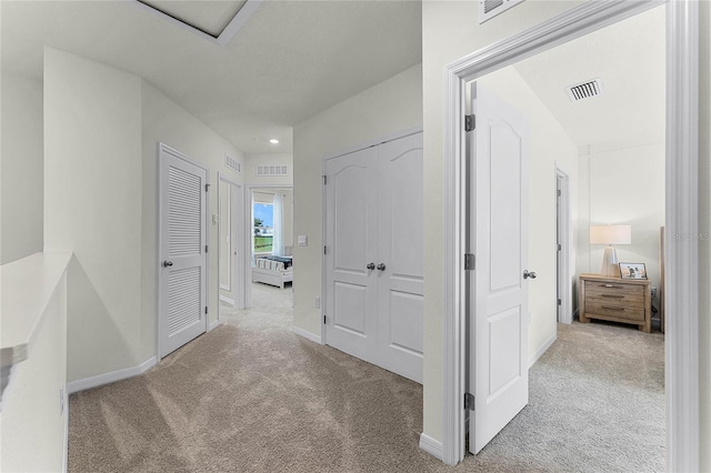 hallway featuring light colored carpet