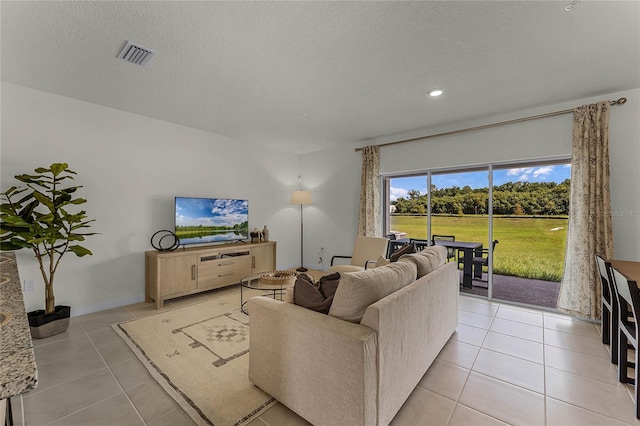 living room featuring a textured ceiling and light tile patterned flooring