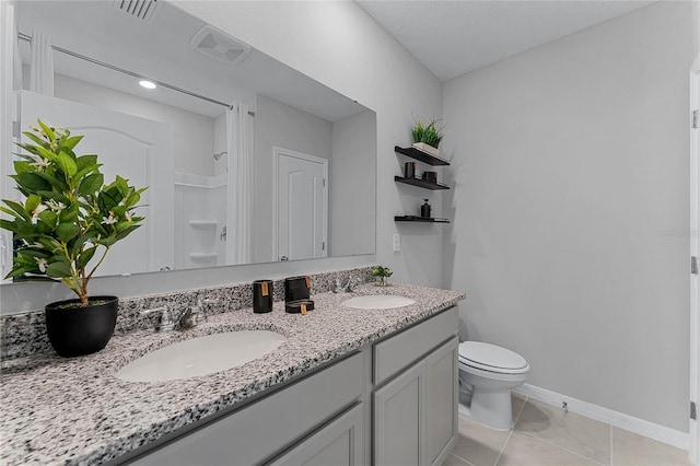 bathroom with vanity, a shower, toilet, and tile patterned floors