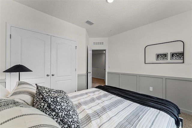 carpeted bedroom with a closet and a textured ceiling