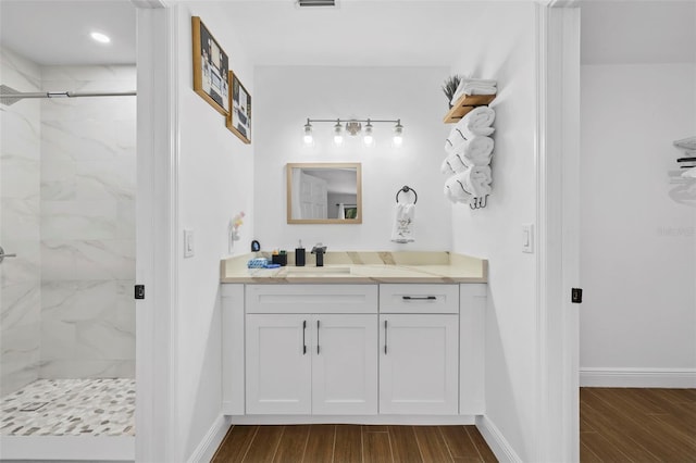 bathroom with a shower with door, vanity, and hardwood / wood-style flooring