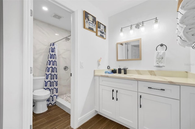 bathroom with a shower with shower curtain, hardwood / wood-style floors, vanity, and toilet