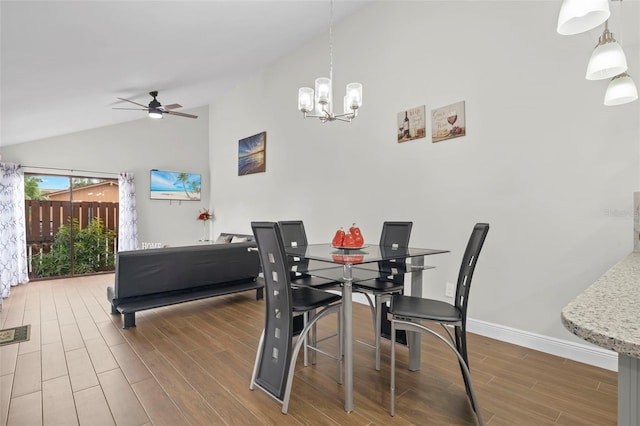 dining area featuring wood-type flooring, ceiling fan with notable chandelier, and lofted ceiling