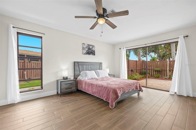 bedroom featuring multiple windows, ceiling fan, hardwood / wood-style flooring, and access to exterior