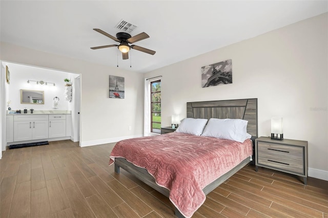 bedroom featuring dark hardwood / wood-style flooring, ensuite bathroom, and ceiling fan