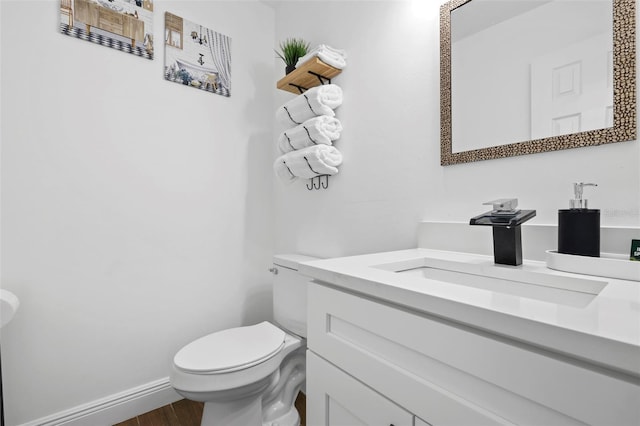 bathroom with hardwood / wood-style floors, vanity, and toilet