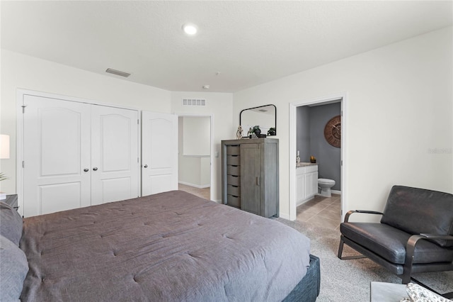 carpeted bedroom featuring a closet and ensuite bathroom