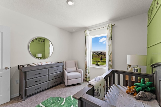 bedroom with light carpet, a nursery area, and a textured ceiling