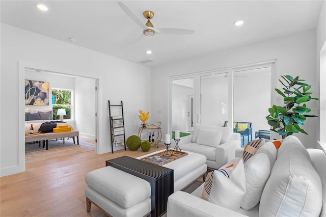 living room with ceiling fan and light hardwood / wood-style flooring