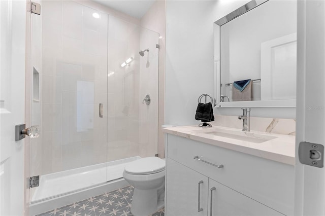 bathroom with a shower with door, vanity, and toilet