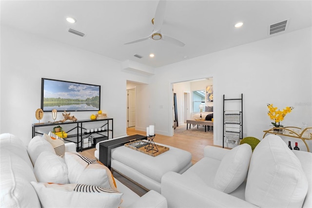 living room featuring ceiling fan and light hardwood / wood-style floors