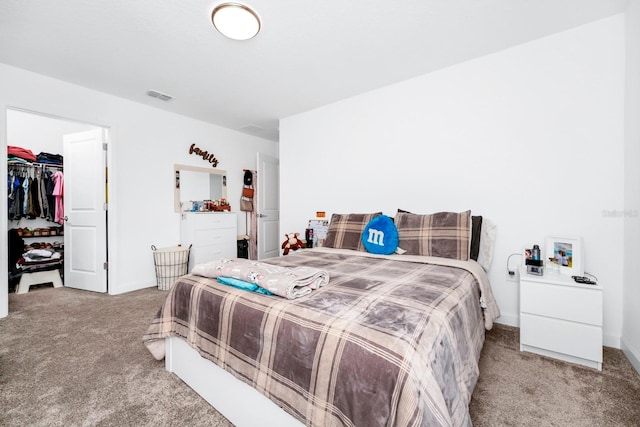 bedroom featuring a closet, carpet floors, and a walk in closet