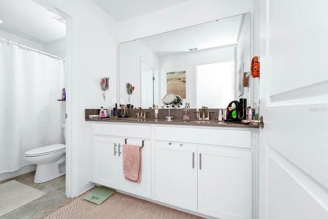 bathroom with vanity, toilet, and tile patterned floors