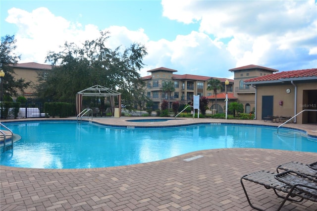 view of pool with a gazebo, a community hot tub, and a patio