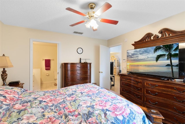 bedroom with ensuite bathroom, ceiling fan, and a textured ceiling