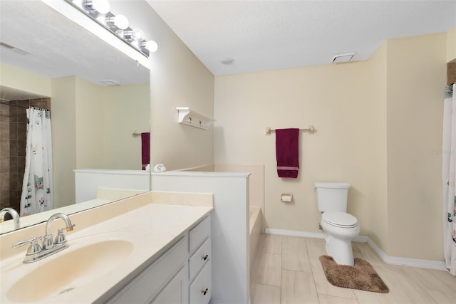 bathroom with curtained shower, vanity, toilet, and a textured ceiling