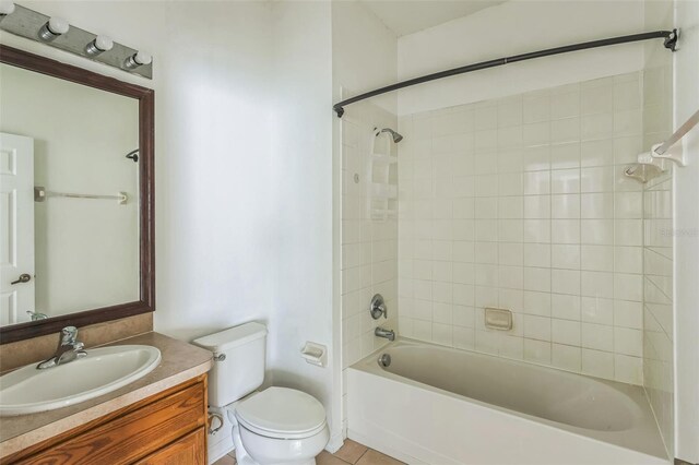 full bathroom with toilet, tiled shower / bath combo, vanity, and tile patterned flooring