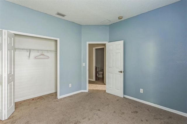 unfurnished bedroom with a closet and light colored carpet