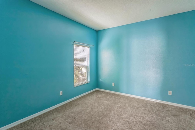 carpeted spare room with a textured ceiling