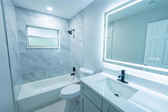 full bathroom with toilet, vanity, and tiled shower / bath