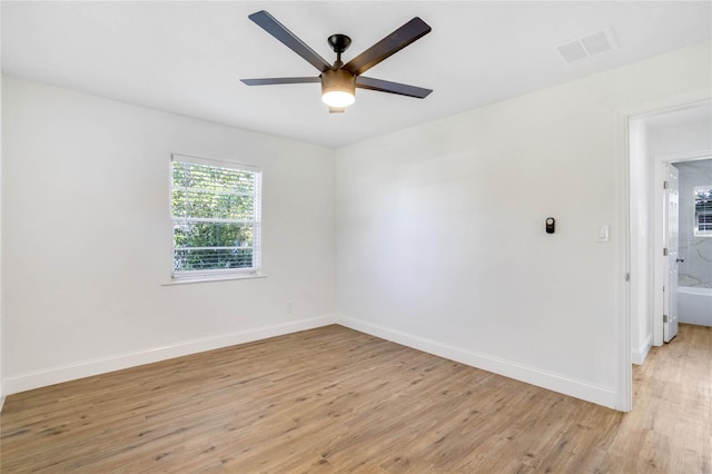 empty room with ceiling fan and light hardwood / wood-style floors