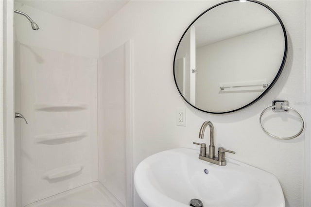 bathroom featuring walk in shower and sink