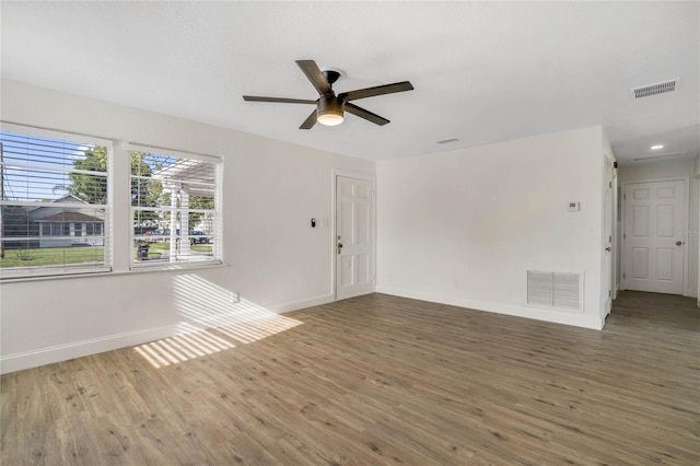 empty room featuring dark wood-type flooring and ceiling fan