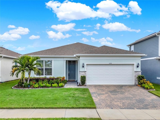 single story home with a garage and a front lawn