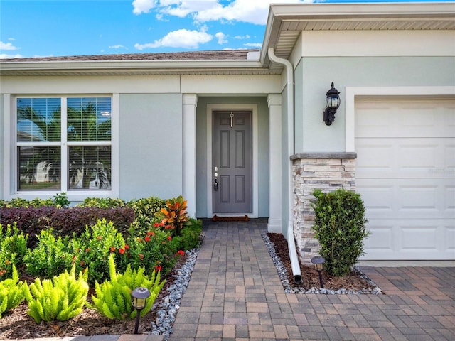 3286 Hanging Tide St, Winter Garden, FL 34787 - entrance to property featuring an attached garage, stucco siding, and stone siding