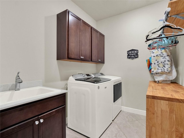 clothes washing area featuring cabinets, washing machine and dryer, sink, and light tile patterned flooring