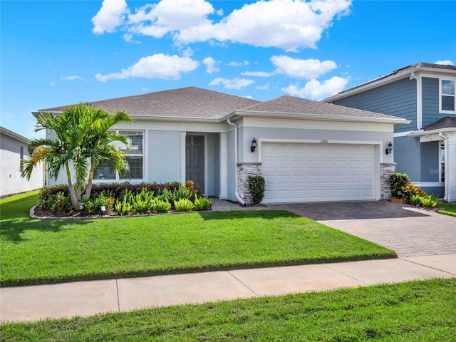 3286 Hanging Tide St, Winter Garden, FL 34787 - view of front of house with stucco siding, decorative driveway, a garage, a front yard, and stone siding