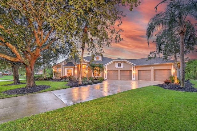 view of front of house with a yard and a garage