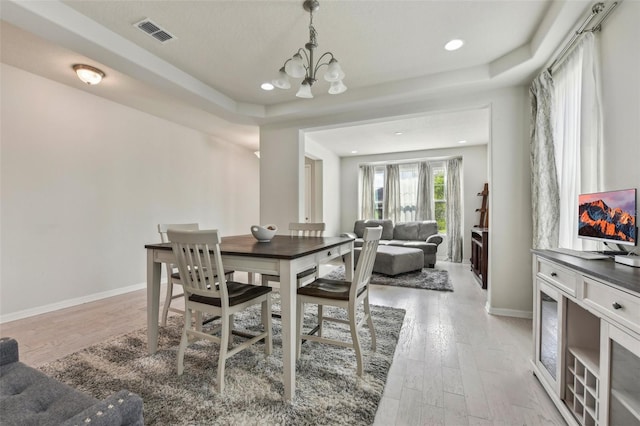 dining room featuring light hardwood / wood-style flooring and a notable chandelier