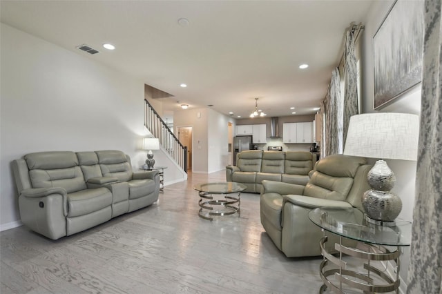 living room with light wood-type flooring and a notable chandelier