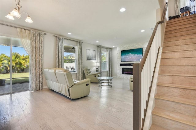 living room with plenty of natural light, a chandelier, and light hardwood / wood-style flooring