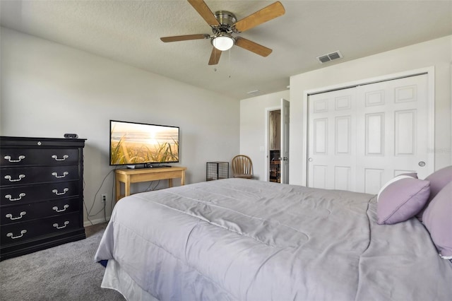 bedroom featuring a closet, a textured ceiling, ceiling fan, and carpet floors