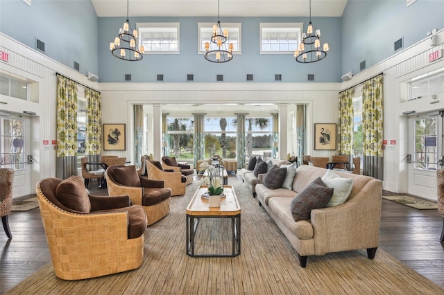 living room with a high ceiling, a chandelier, and hardwood / wood-style flooring