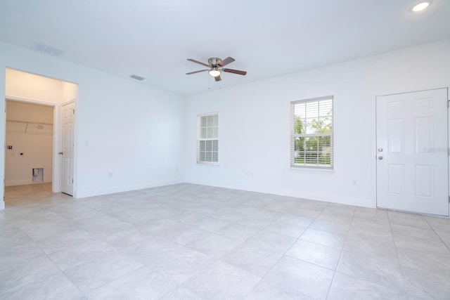 empty room with light tile patterned floors and ceiling fan