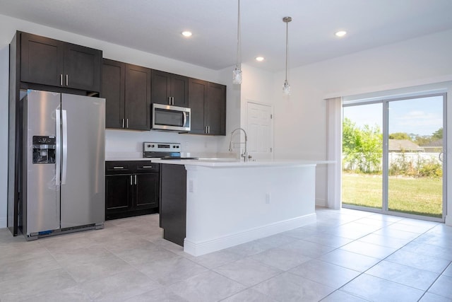 kitchen featuring a center island with sink, dark brown cabinetry, decorative light fixtures, and stainless steel appliances