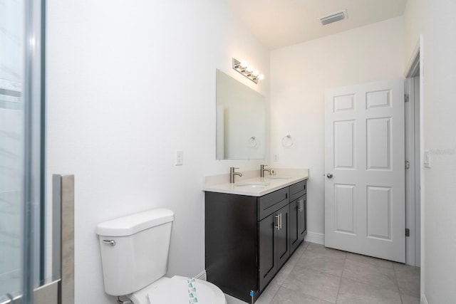 bathroom with vanity, toilet, and tile patterned flooring