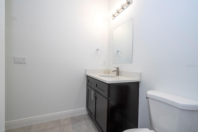 bathroom with toilet, vanity, and tile patterned floors