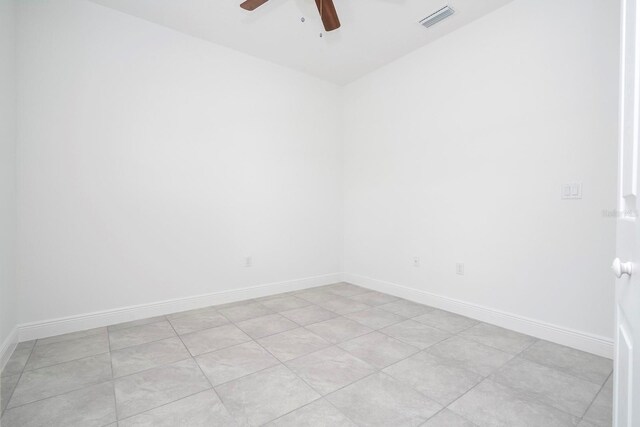 empty room with ceiling fan and light tile patterned floors