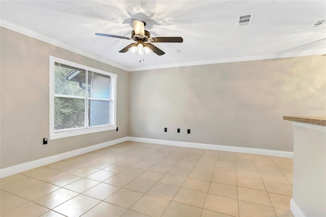 tiled empty room featuring ceiling fan and ornamental molding