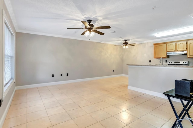 kitchen with stove, crown molding, light tile patterned floors, light brown cabinetry, and light stone counters