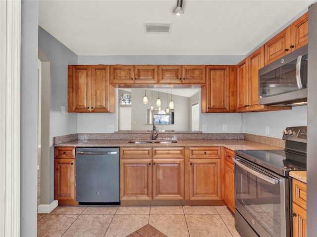 kitchen featuring light stone countertops, sink, light tile patterned floors, and stainless steel appliances