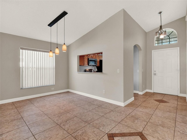 entrance foyer featuring high vaulted ceiling, a chandelier, and light tile patterned floors